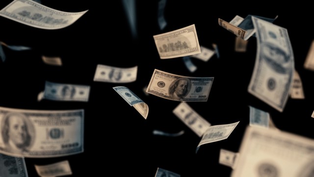 100 dollar bills falling in slow motion with Depth of Field camera Focus.