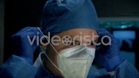 Cinematic Slow-motion of Male Surgeon Doctor Putting On Protective Medical Face Mask in Surgery Room.