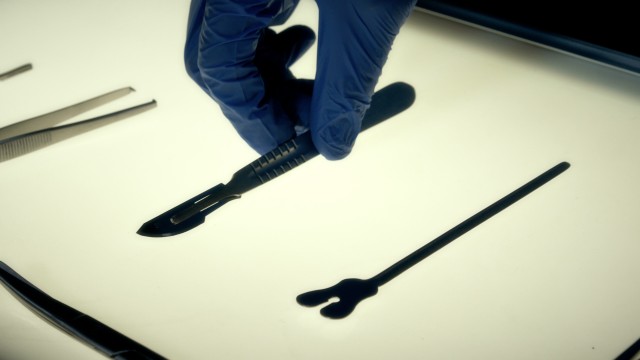 Cinematic Macro Shot of Doctor's Hand Grabbing Medical Scalpel. Close Up Shot of Medical Tools.