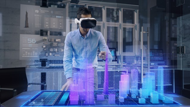Professional Male Architect wearing Augmented Reality Glasses makes gestures and redesigns 3D City Model. 