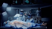 Team of Medical Surgeons use Augmented Holographic Technology to examine Patient. Nurse uses Hand Gestures to show the Organs, Bones and Full Anatomy of the Body of a Male Patient. Shot on RED Epic W.