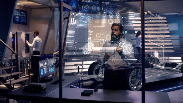 Engineers analyzing futuristic car chassis with digital screens.