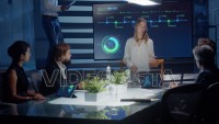 Female executive talks to board of directors and investors using a digital interactive monitor for presentation with green elements.