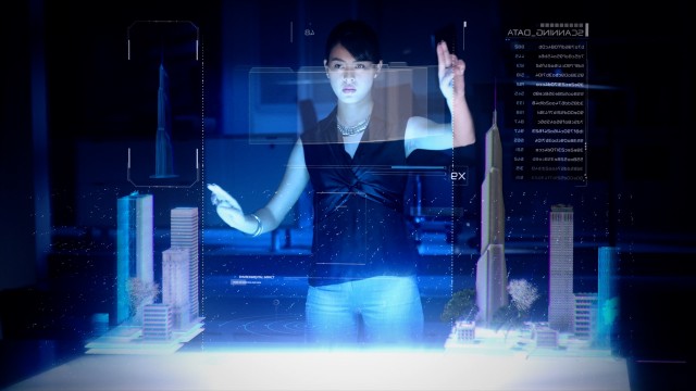 Professional Female Architect makes gestures and redesigns 3D City Model on Holographic Interface. 