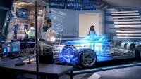 Engineers analyzing futuristic holographic car through a digital screen.