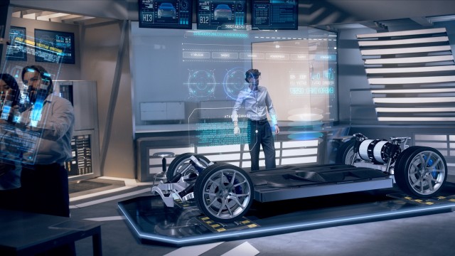 Automotive Engineers Analyzing Design and Performance of Electric Car Prototype using Augmented Holographic Technology and Futuristic Screens. High-tech Industrial Facility. Shot on RED Epic W Helium.