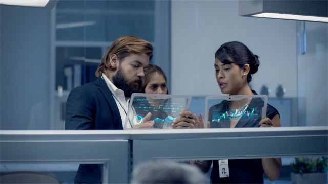 Diverse team of Corporate Professionals Working late at night Analyzing data on Digital Futuristic Tablets, Discussing Information of Growth of the Company and Forecast. Shot on RED Epic W Helium 8K.