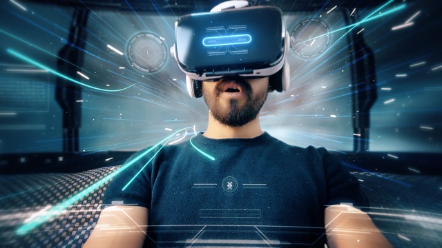 Bearded man uses VR-headset display for virtual reality game while entering an immersive holographic experience with infographics in UHD 4K. Concept of virtual hologram, simulation, gaming.
