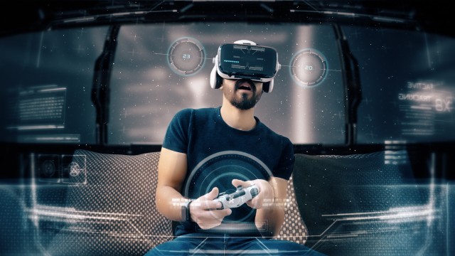 Young man playing a video game wearing a VR-headset. Concept of virtual hologram, simulation, gaming.