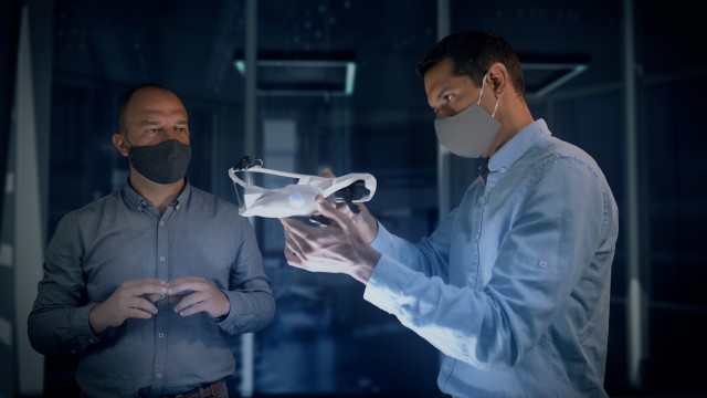Close Up of Professional Engineers and Designers Wearing Protective Face Masks Work with a Futuristic Concept Face Mask Prototype Model.
