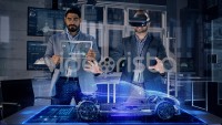 Male Automotive Designers in Suit Wearing AR Headset and Transparent Tablet Analyzing 3D Electric Concept Car Model. 