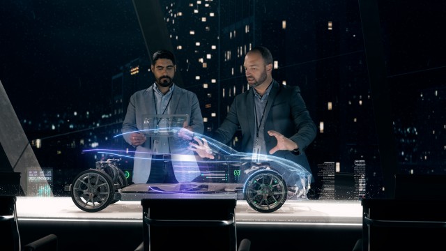 Automotive engineers working on design of Detailed Electric Car Chassis using futuristic transparent screens and AR Holographic Surface High Tech Table.
