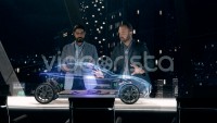 Automotive engineers working on design of Detailed Electric Car Chassis using futuristic transparent screens and AR Holographic Surface High Tech Table.